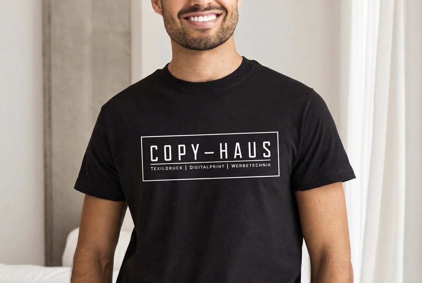 Mann im T-Shirt mit Copy-Haus Logo